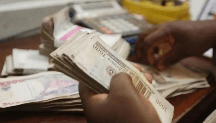 Hands counting 1000 naira notes